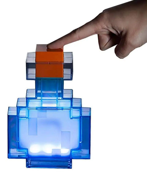 Potion Bottle Color Changing LED Desk Lamp With Pixelated Design, 7 Inch Night Light For Gamers, glowing blue in dark, hand touching top