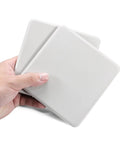 Hand holding two Four Pack Five Inch Reusable Carpet Furniture Sliders Beefy Moving Pads Heavy Duty Sliders For Moving Sofas Beds And Chairs