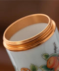 Close-up view of the gold lid of Top Tier Ceramic Food Storage Jars Set Of Twelve With Airtight Snap Lids.