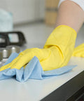 Person cleaning surface with blue shop towel roll, part of 55 count bulk pack for auto shops and garages, durable and absorbent.