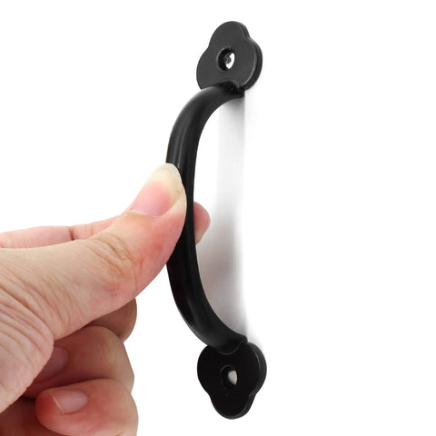 Close-up of a hand holding a black metal handle from the 12 Pack Rustic Barn Door Handles Set 4 Inch Length Hole To Hole 3.2 Inches.