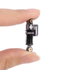 Close-up of 43mm Aluminum Threaded Tele Shocks Absorbers Dope Upgrade Kit For Axial SCX24 with reservoir in hand.