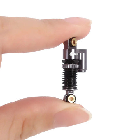 Close-up of 43mm Aluminum Threaded Tele Shocks Absorbers Dope Upgrade Kit For Axial SCX24 with reservoir in hand.