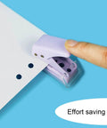 User demonstrating the Two Pack Mini Purple And Pink One Quarter Inch Circle Hole Punch Handheld Paper And Leather Craft Tool punching paper.