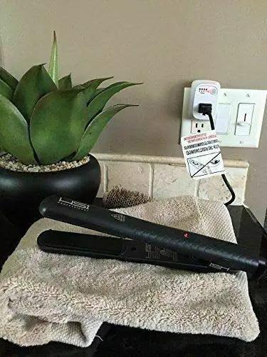 No Fuss Single Outlet Safety Timer With Push Button Countdown Automatic Shutoff shields hair straightener on towel near plant.