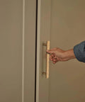 Hand pulling Luxurious Zinc Alloy Cabinet Handle with 5 Inch Hole Centers in Champagne Bronze on a wardrobe door.