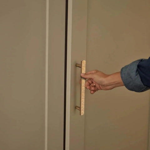 Hand pulling Luxurious Zinc Alloy Cabinet Handle with 5 Inch Hole Centers in Champagne Bronze on a wardrobe door.