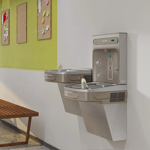 EZH2O Bottle Filling Station With Bi Level ADA Cooler Filtered Non Refrigerated Stainless Steel Hydration Station Featuring Touchless Sensor Sleek 1.5 GPM Fill Rate And LED Filter Status Indicator mounted on a wall.