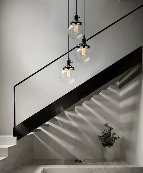 Three Light Industrial Cluster Pendant Ceiling Fixture with 5.9 Inch Clear Globe Shades in Black Finish for foyers or stairs