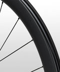 Close-up of 105 Rs710 C46 Carbon Road Wheelset Tubeless 700c Hooked Rim 46mm Deep showing black carbon rim and spokes.