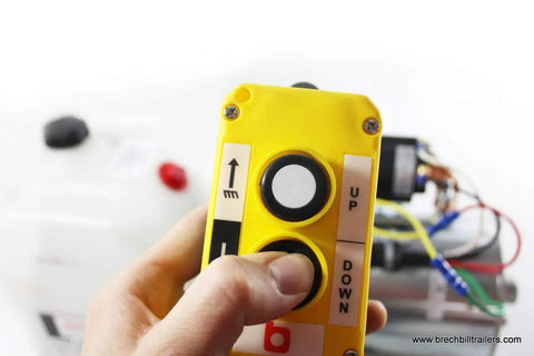 Close-up of hand holding remote for Beefy Double Acting Hydraulic Pump Assembly With Power Up And Power Down, 3200 PSI Max, 2 GPM.