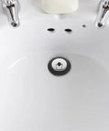 Rubber Bathtub Drain Stopper Plug with Stainless Steel Seal installed in a clean white sink, showcasing modern design.