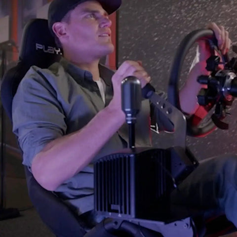 Man using Universal Sim Racing Gear Shifter and Handbrake Mount Adjustable Cockpit Bracket in gaming seat setup.