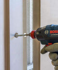 THDB25234CS Titen HD 1/4 Inch By 2-3/4 Inch Zinc Plated Countersunk Head Heavy Duty Screw Anchor being used with a drill on a door frame
