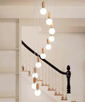 Top Shelf Three Head Disc Pendant Ceiling Light With Milky Frosted Glass Lampshades And Heavy Duty Wrought Iron Frame hanging above stairs.