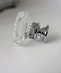 Close-up of a crystal cabinet knob set with glass doorknobs and chrome base, sparkling drawer pull for cabinets and dressers.