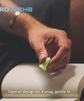 Person holding a green foam ear plug from Multi Purpose Foam Ear Plugs With Case For Sleep Travel Work Concerts Shooting Snoring Studying And Loud Noise Reduction NRR 33 Green Made In USA 10 Pairs, illustrating the tapered design for comfort.