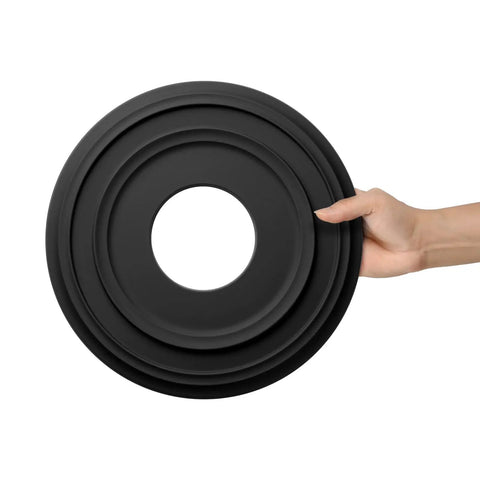 Hand holding Matte Black PU Ceiling Medallion For Light Fixtures And Ceiling Fans, Twelve And A Quarter Inch Outer Diameter.