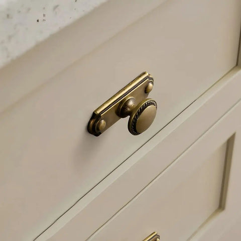 Antique Brass Cabinet Knobs with Industrial Backplates on kitchen drawer, vintage pulls, concealed backplate design for rustic farmhouse vibe.