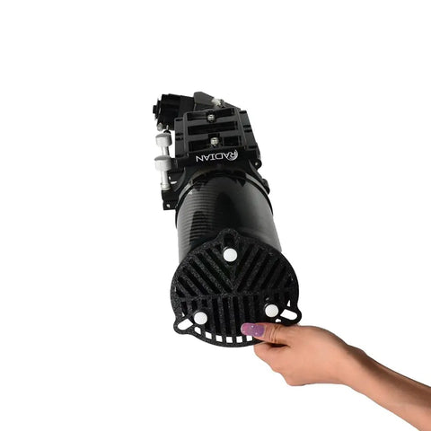 Person holding black cylindrical mechanical part with visible RADIAN label, showcasing grip handle detail.
