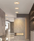 Top Shelf 9 Pack 3 Inch LED Recessed Downlights With Sleek Baffle Trim illuminating a modern hallway with marble walls.