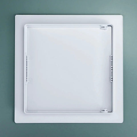 Rock Hard Eight By Eight Inch Drywall Access Panel Two Pack ABS Plastic Wall Cover Plate top view against a green background.