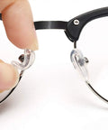 Super Comfy Silicone Airbag Glasses Nose Pads With Hella Soft Metal Support, clear silicone pad being attached to glasses.