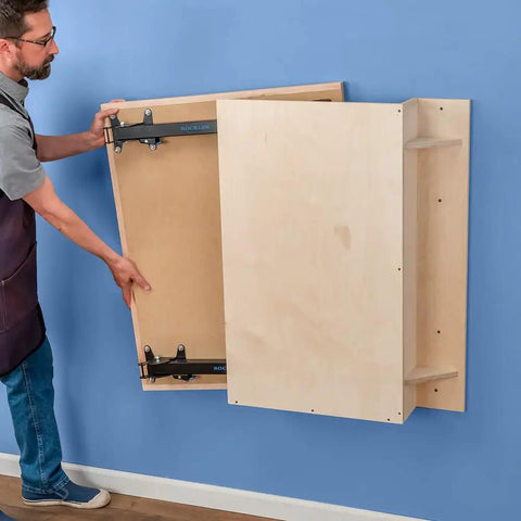 Man folding Knock Down Outfeed Table Kit with foldable legs for small shops against blue wall