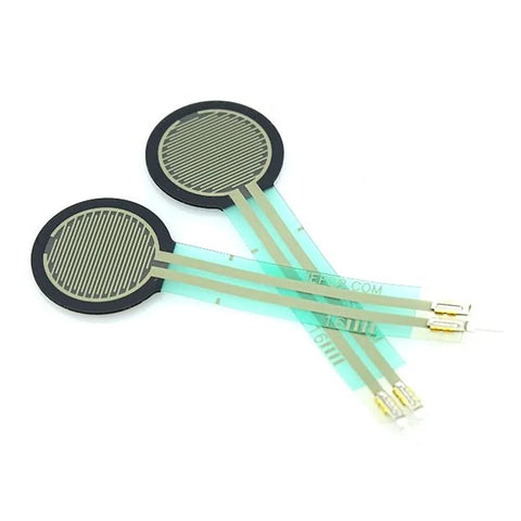 Two round FSR402 pressure sensors with green flex leads and gold contact pads