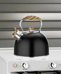 2.6 Quart Whistling Tea Kettle For Stovetop Black, Durable 304 Stainless Steel on white stove, featuring wood-like handle