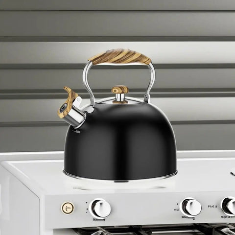 2.6 Quart Whistling Tea Kettle For Stovetop Black, Durable 304 Stainless Steel on white stove, featuring wood-like handle