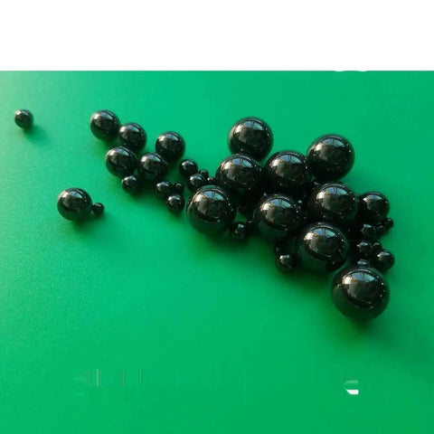 Twenty Piece Lot Of 1.588Mm Silicon Nitride Ceramic Balls G5 Grade on green surface, showcasing precision drop-in replacements for bike hubs.