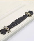 Vintage Leather Look PU Peel Handle Drawer Pulls For Cabinets And Luggage 7.48 Inch Black 2 Pack installed on white cabinet