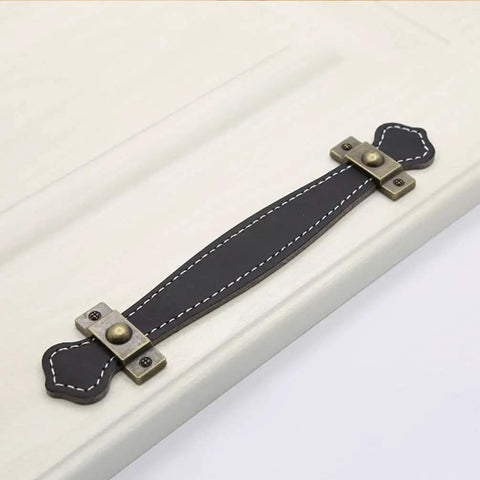 Vintage Leather Look PU Peel Handle Drawer Pulls For Cabinets And Luggage 7.48 Inch Black 2 Pack installed on white cabinet