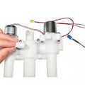 Person holding 12V DC Smart Toilet Bidet Dual Solenoid Water Valve Manifold ZNF-A with wires and threaded ports for home installation