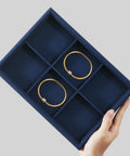 Super Slick Microfiber Jewelry Display Tray With Six Grid Compartments For Ring Earring Bracelet And Necklace Storage Stackable Countertop Organizer Plate Hits Different showing two gold bangles in a navy tray.