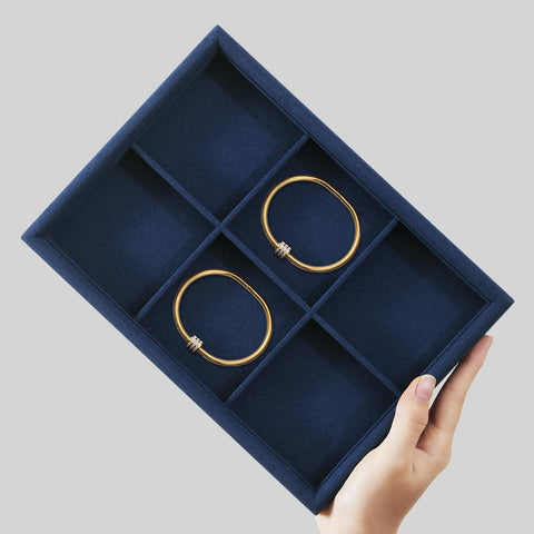 Super Slick Microfiber Jewelry Display Tray With Six Grid Compartments For Ring Earring Bracelet And Necklace Storage Stackable Countertop Organizer Plate Hits Different showing two gold bangles in a navy tray.