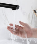 Matte Black Tub Spout For Bathtub And Shower Non Diverter Wall Mount Round Shape 180 Degree Swivel 1/2 Inch NPT Thread Water Saving Rotatable Spout Easy Install For A Slick Modern Bath Upgrade with water flowing into a palm
