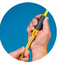 Close-up of hands using Lil Ripper Wire Stripper With Slitting Blade on a yellow cable against a blue background