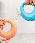 5 Piece Beach Sand Set For Kids And Boys Portable Lightweight Plastic Shovels And Buckets Water Play Kit For Creativity And Summer Fun On The Beach This Summer, hands pouring water between blue and orange plastic toys