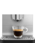 No Sweat Brewing Fully Automatic Espresso Machine With Integrated Grinder And One Touch Milk Frother For Silky Lattes Bold Shots And Ten One Tap Presets 19 Bar Pressure Compact Space Saving Matte Black brewing a shot of espresso in a glass cup.