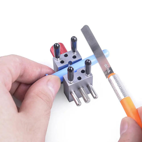 High Precision Mini Vise With Adjustable Jaws Up To 1.18 Inches For Models Hobbies Crafts Jewelry Watches And Small Electronics Tiny But Mighty Clamp For Delicate Parts, holding a small blue rod with saw nearby