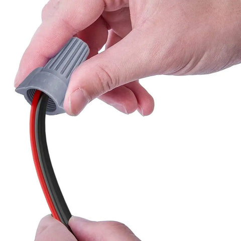 Hand attaching wire into a gray cap from the 100 Piece Color Coded Wire Nut Assortment Kit With Winged Wire Caps Stainless Steel Terminals