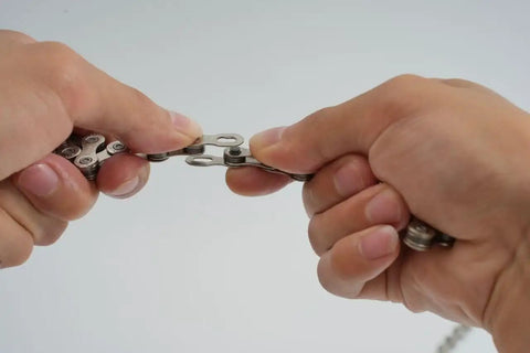 Hands demonstrating use of All In One Bike Chain Kit With 126 Links For 6/7/8 Speed Chains, Built In Chain Tool, Replacement Set For Hub Motor E Bikes