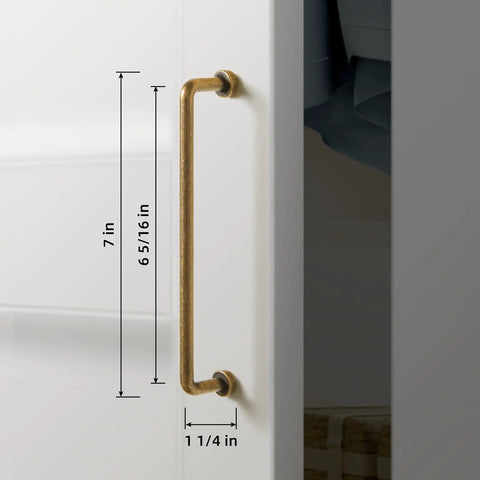 Close-up of a 6 Pack 6 5/16 Inch Center-To-Center Antique Brass Cabinet Bar Pull on a white cabinet door