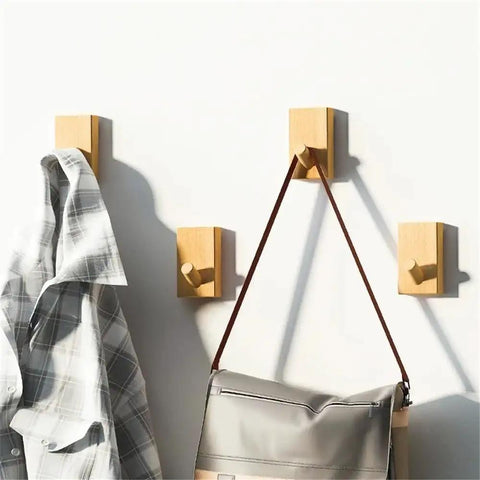 Modern Wall Mounted Coat Rack With Smooth Beige Finish Sleek Space Saving Design For Entryways holding a gray plaid shirt and a bag.