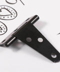 Close-up of a black T-shaped hinge on white background with three screw holes visible.