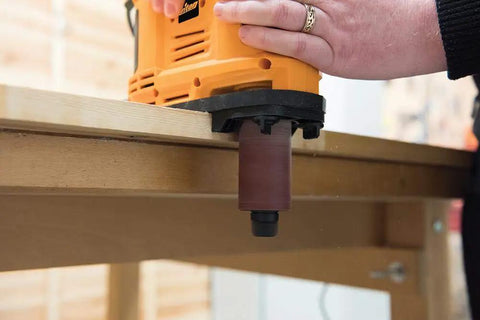 Heavy Duty 650W Portable Oscillating Spindle Sander With Variable 1800 To 3200 RPM Speed sanding an edge on a wooden surface.