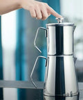 Aqua Turkish Teapot Set In Eighteen Ten Stainless Steel With Double French Press Samovar Style Kettle With Metal Handles on stove.