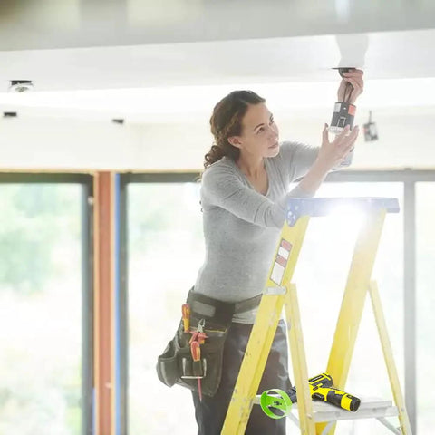 Person using Four And A Quarter Inch Carbide Hole Saw With Arbor For Recessed Lights on ceiling from ladder